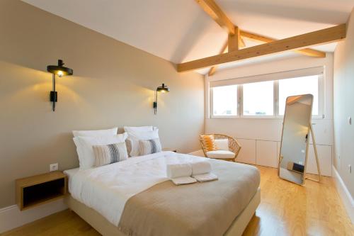 a bedroom with a large white bed and a window at Soulmade Porto in Porto