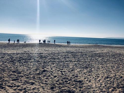 a group of people walking on the beach at Washington House Hotel in Bournemouth