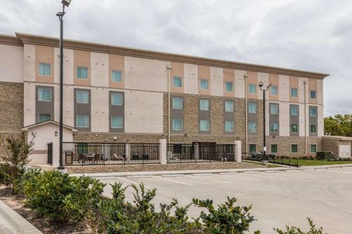 a large building with a parking lot at Sleep Inn & Suites College Station near University in College Station