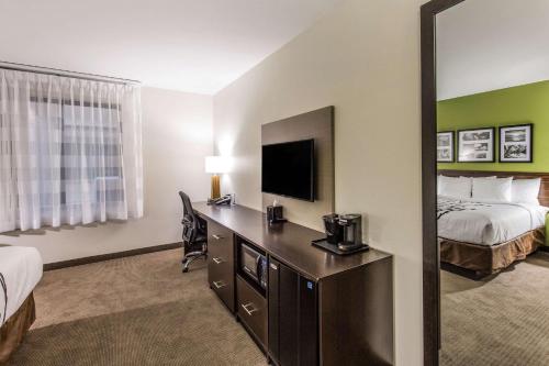 a living room with a television and a coffee table at Sleep Inn Dallas Love Field-Medical District in Dallas