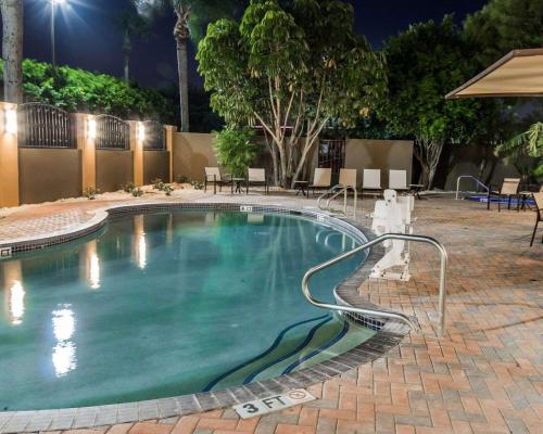a large swimming pool with a hose in a courtyard at night at Comfort Inn & Suites Pharr - McAllen in Pharr