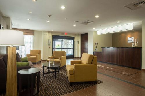 a lobby with a waiting room with chairs and a table at Sleep Inn & Suites Ingleside - Corpus Christi in Ingleside