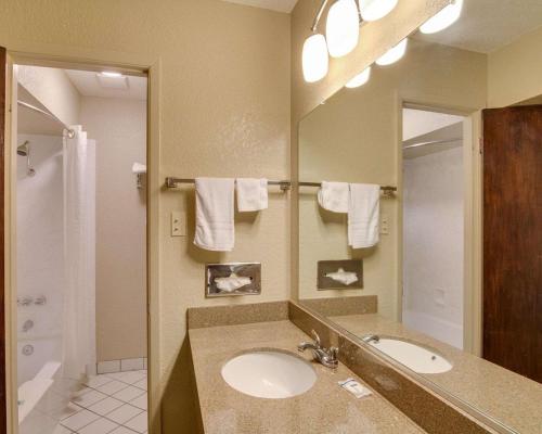 a bathroom with two sinks and a large mirror at Days Inn by Wyndham Gatesville in Gatesville