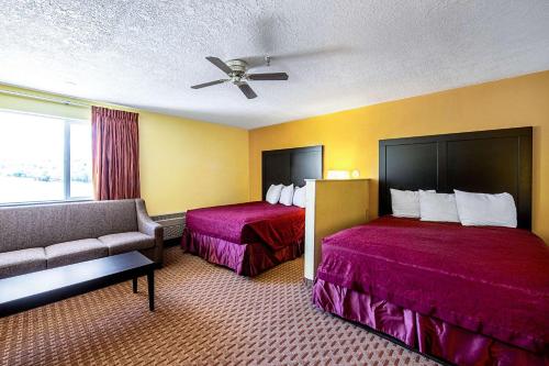 a hotel room with two beds and a couch at Rodeway Inn & Suites in Monticello