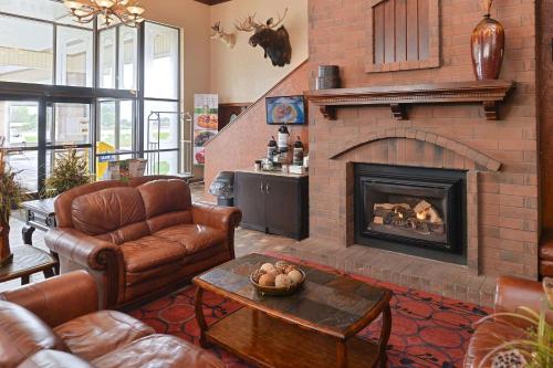 a living room with leather furniture and a fireplace at Quality Inn Vernal near Dinosaur National Monument in Vernal