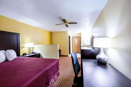a hotel room with a bed and a ceiling fan at Rodeway Inn & Suites in Monticello