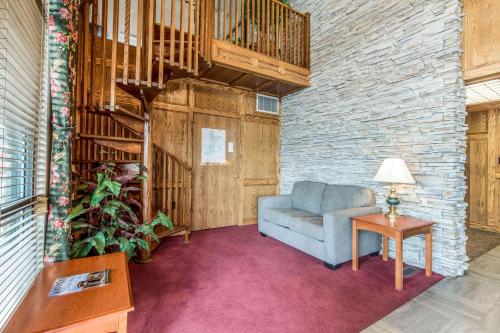 a living room with a blue couch and a wooden staircase at Quality Inn Cedar City - University Area in Cedar City