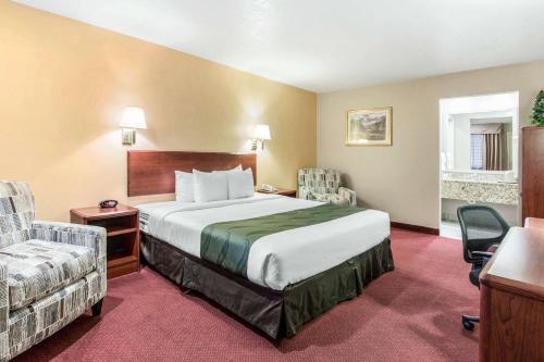 Habitación de hotel con cama y silla en Quality Inn Cedar City - University Area, en Cedar City