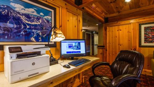 a computer sitting on a desk with a chair at Best Western Plus Olympic Inn in Klamath Falls