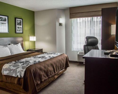 a hotel room with a bed and a chair at Sleep Inn Historic Williamsburg in Williamsburg