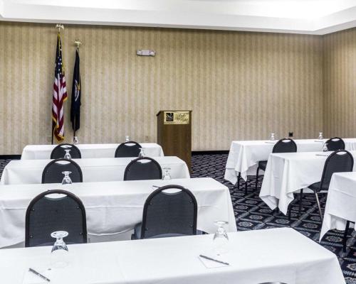 a room with white tables and chairs and flags at Quality Suites Lake Wright - Norfolk Airport in Norfolk