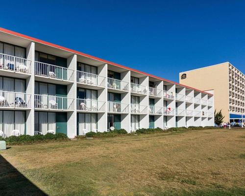 an apartment building with tables and chairs on the balconies at Ocean27 Hotel in Virginia Beach