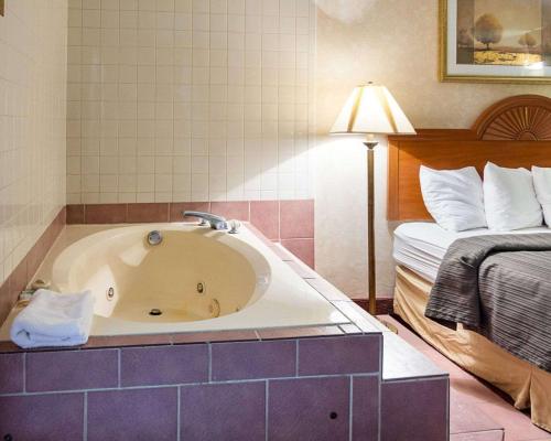 a bath tub in a hotel room with a bed at Quality Inn Petersburg Near Fort Gregg-Adams in Southern Estates
