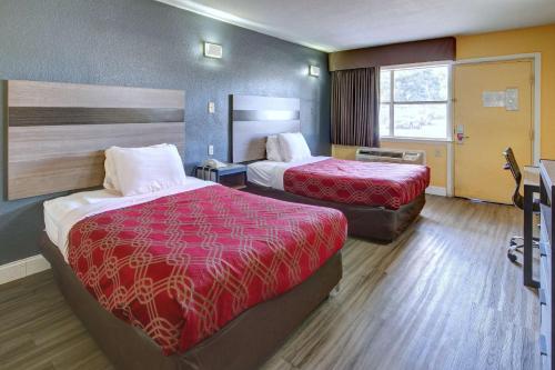 a hotel room with two beds and a window at Econo Lodge at Military Circle in Norfolk