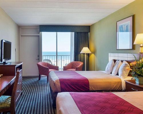a hotel room with two beds and a balcony at Ocean27 Hotel in Virginia Beach