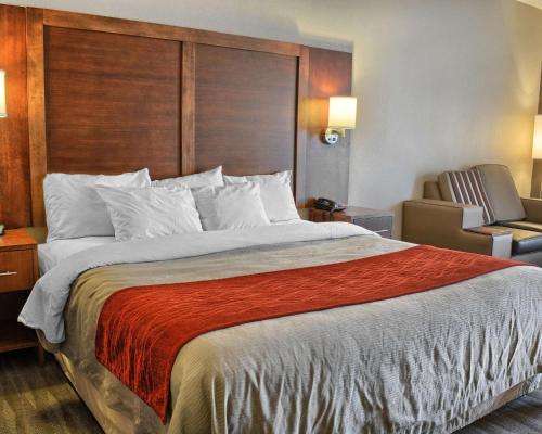 a hotel room with a large bed and a chair at Comfort Inn Ruther Glen near Kings Dominion in Ruther Glen