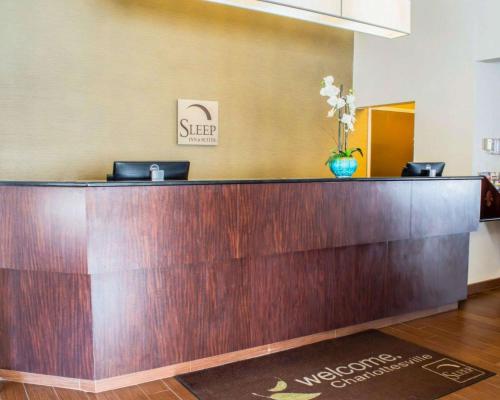 a lobby with a reception desk with a vase of flowers at Sleep Inn & Suites Monticello in Charlottesville