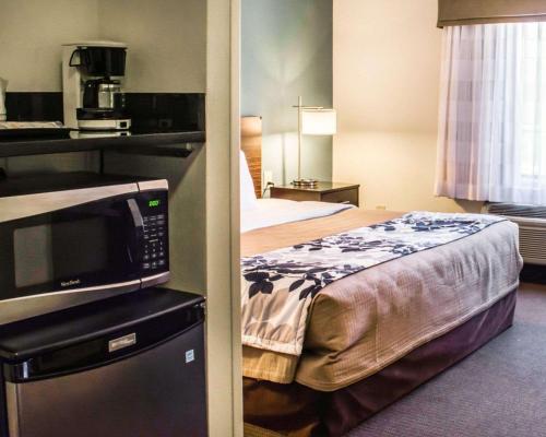 a hotel room with a bed and a microwave at Sleep Inn & Suites Monticello in Charlottesville