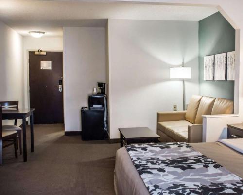 a hotel room with a bed and a couch and a table at Sleep Inn & Suites Monticello in Charlottesville