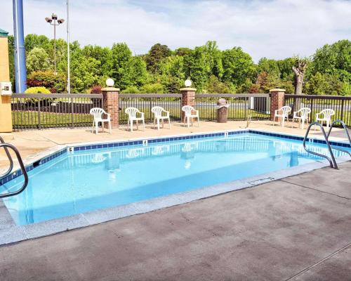a swimming pool with chairs and a fence at Quality Inn Thornburg in Thornburg