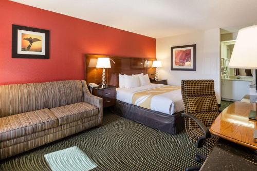 a hotel room with a bed and a couch at Quality Inn Christiansburg - Blacksburg in Christiansburg