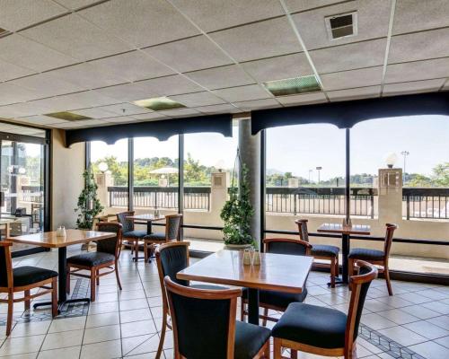 a restaurant with tables and chairs and windows at Quality Inn Troutville - Roanoke North in Troutville