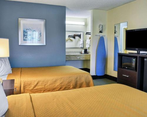 a hotel room with two beds and a flat screen tv at Quality Inn Thornburg in Thornburg
