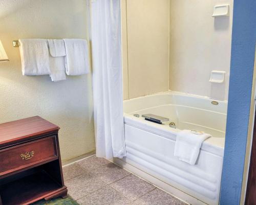 a bathroom with a tub and a shower with towels at Quality Inn Thornburg in Thornburg