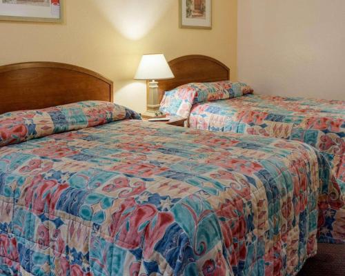 a hotel room with two beds and a lamp at Rodeway Inn Colonial Heights I-95 in Colonial Heights