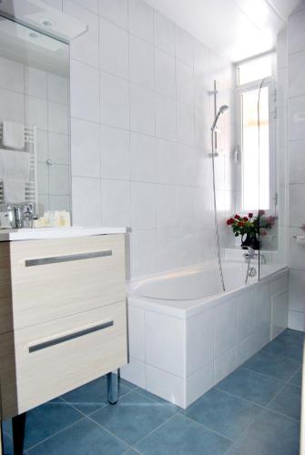 une salle de bain blanche avec une baignoire et un lavabo dans l'établissement Hôtel Le Grand-Bec, à Pralognan-la-Vanoise