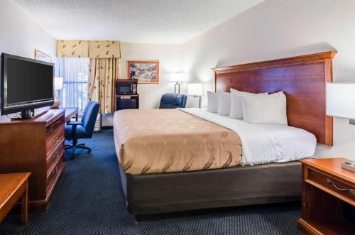 a hotel room with a bed and a flat screen tv at Quality Inn Lynchburg near University in Lynchburg