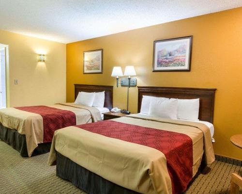 two beds in a hotel room with yellow walls at Econo Lodge Fredericksburg near I-95 in Fredericksburg
