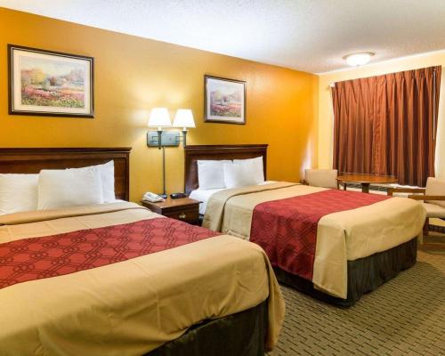 una habitación de hotel con 2 camas y una silla en Econo Lodge Fredericksburg near I-95, en Fredericksburg