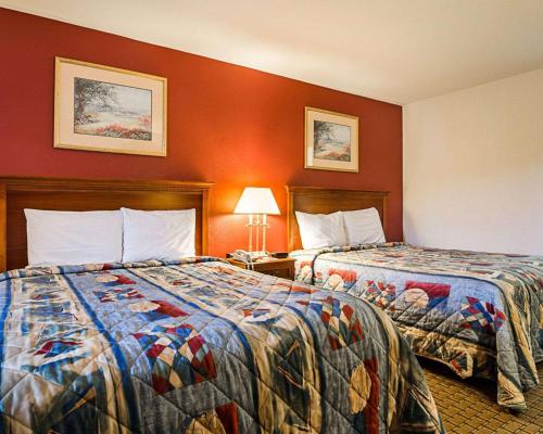 2 Betten in einem Hotelzimmer mit roten Wänden in der Unterkunft Econo Lodge in Richmond
