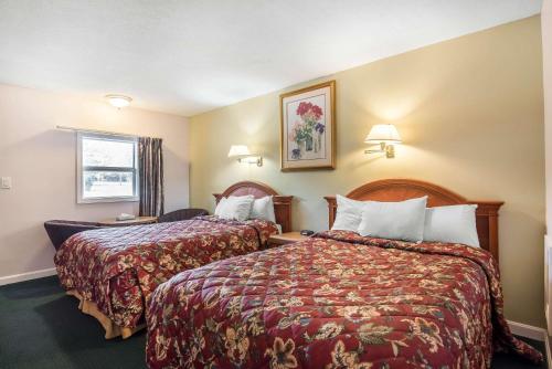 Rodeway Inn في Bellows Falls: غرفة فندقية بسريرين ونافذة