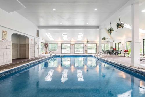 a large swimming pool with blue water in a building at Quality Inn Shelburne - Burlington in Shelburne