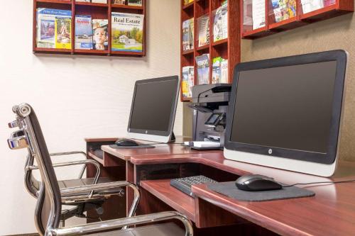 a desk with a computer monitor and a keyboard and mouse at Comfort Inn & Suites Near Burke Mountain in Saint Johnsbury