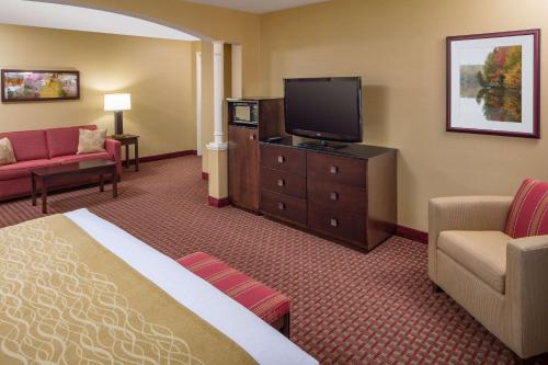 a hotel room with a bed and a flat screen tv at Comfort Inn & Suites Near Burke Mountain in Saint Johnsbury