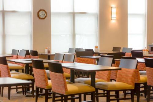 a room with tables and chairs and a clock at Comfort Inn & Suites Near Burke Mountain in St. Johnsbury