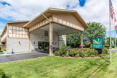 a clubhouse with a sign in front of a building at Quality Inn Shelburne - Burlington in Burlington