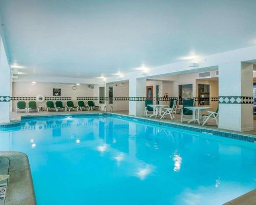 a large pool in a hotel with chairs and tables at Comfort Inn & Suites Near Burke Mountain in St. Johnsbury