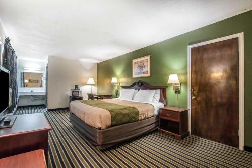 a hotel room with a bed and green walls at Econo Lodge in Brattleboro
