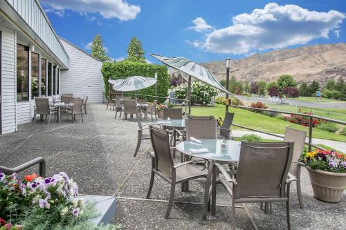 a patio with tables and chairs with mountains in the background at Holiday Inn Clarkston - Lewiston by IHG in Clarkston