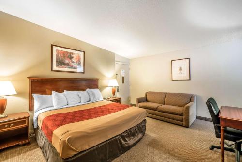 a hotel room with a bed and a couch and a desk at Holiday Lodge Yakima in Yakima