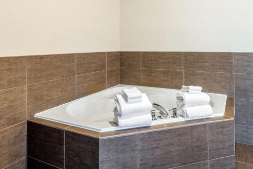 a bathroom with a tub with towels on it at Comfort Suites Yakima in Yakima