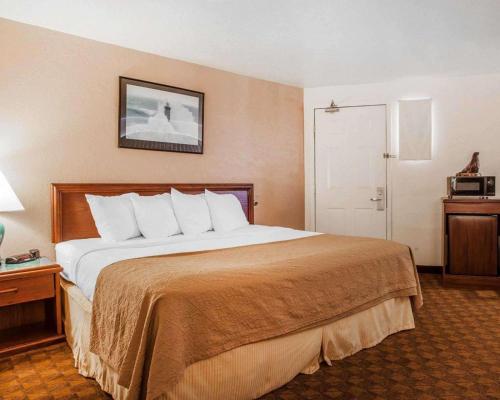 a hotel room with a large bed and a large mirror at Quality Inn Port Angeles - near Olympic National Park in Port Angeles