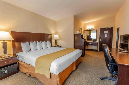 a hotel room with a large bed and a desk at Quality Inn Arlington in Arlington