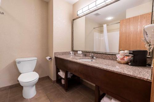 a bathroom with a toilet and a sink with a mirror at Comfort Inn & Suites in Walla Walla
