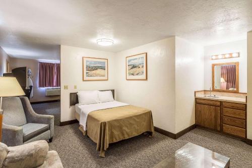 um quarto de hotel com uma cama e uma cadeira em Quality Inn em Moses Lake