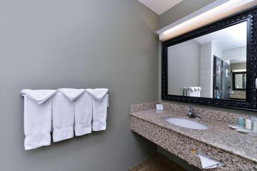 a bathroom with a sink and a mirror at Comfort Suites Airport Tukwila Seattle in Tukwila